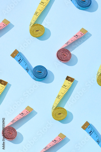 Colorful measure tapes pattern with shadows.