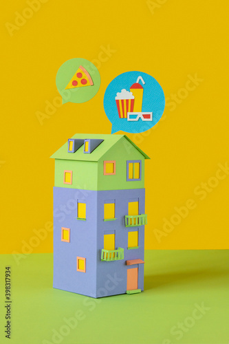 Handmade paper house with food signs above. photo