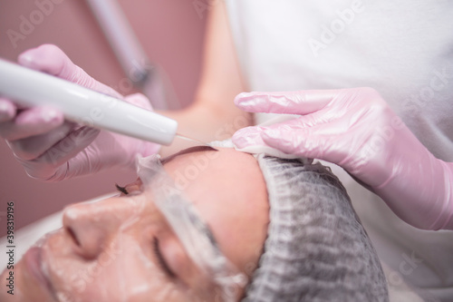  Beautician makes facial cleansing for a girl in the salon