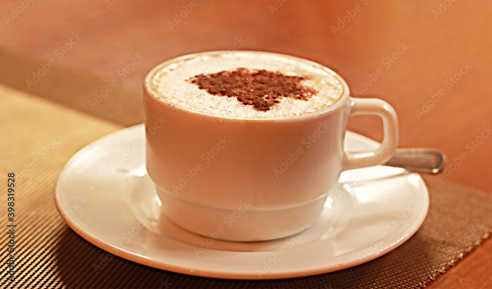 Cup of coffee with chocolate in a white cup on a wooden background. Warm background.