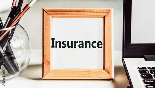 INSURANCE word in wooden frame on office table. photo