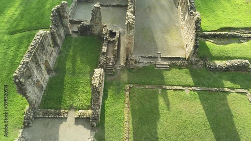 Basingwerk abbey landmark medieval abandoned Welsh ruins Aerial view rising tilting down photo