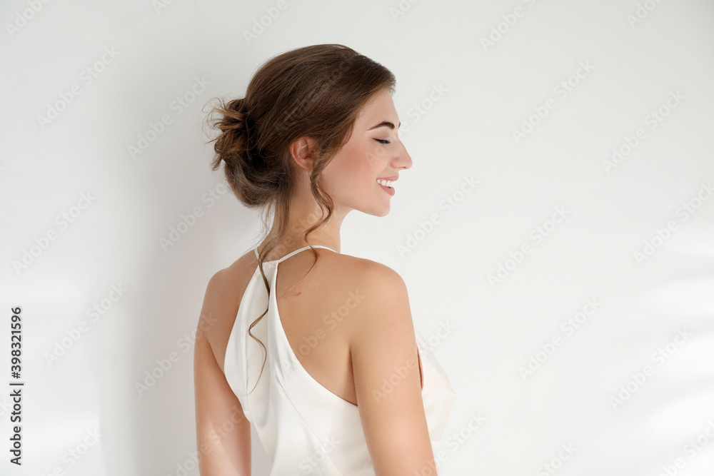 Young bride wearing beautiful wedding dress on light background Young bride wearing beautiful wedding dress on light background