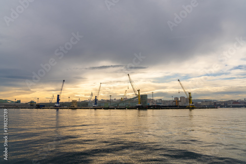 a view of the industrial port and harbor in La Coruna in golden morning light © makasana photo