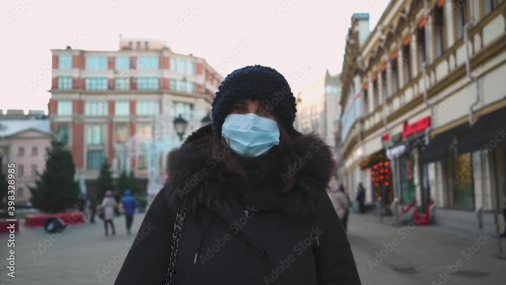 A woman alone on the street in Moscow in a medical mask that protects from the coronavirus pandemic, a portrait of a woman's face in a mask in winter weather. A woman alone on the street in Moscow in a medical mask that protects from the coronavirus pandemic, a portrait of a woman's face in a mask in winter weather.