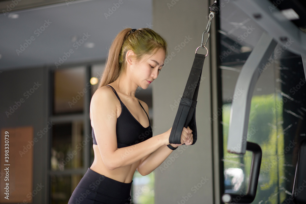 Beautiful Asian fitness woman is training with sport equipment in fitness gym. Fitness and health concept . Beautiful Asian fitness woman is training with sport equipment in fitness gym. Fitness and health concept .