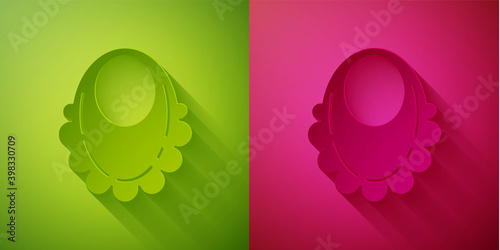 Paper cut Baby bib icon isolated on green and pink background. Paper art style. Vector.