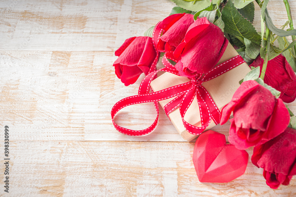 Valentines Day concept, Red Roses and Gift Boxes with Festive Ribbon and Heart Decor on White wooden table background copy space. Romantic floral background.