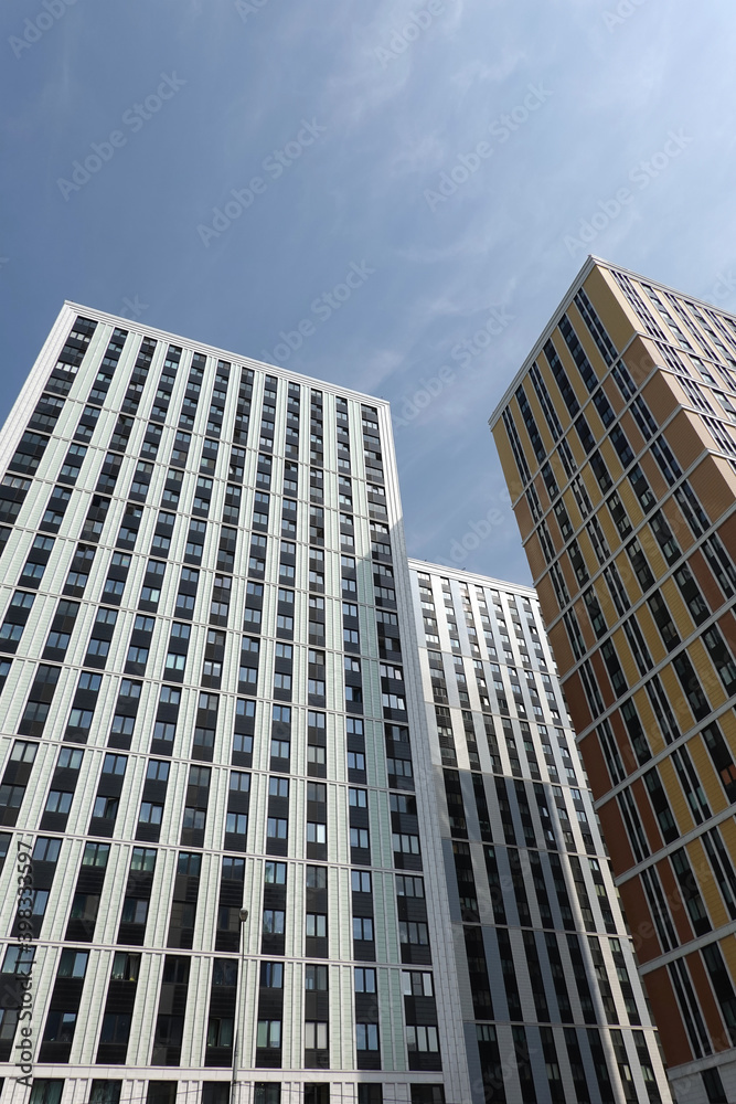 High bottom up perspective view of modern city skyscraper buildings with many windows in the urban cluster