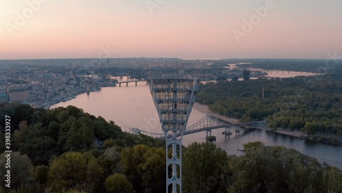 turned off the light tower at the football stadium before turning on. Switching on the light tower of a football stadium against a sunset and a night city cinematic smooth movement of a drone