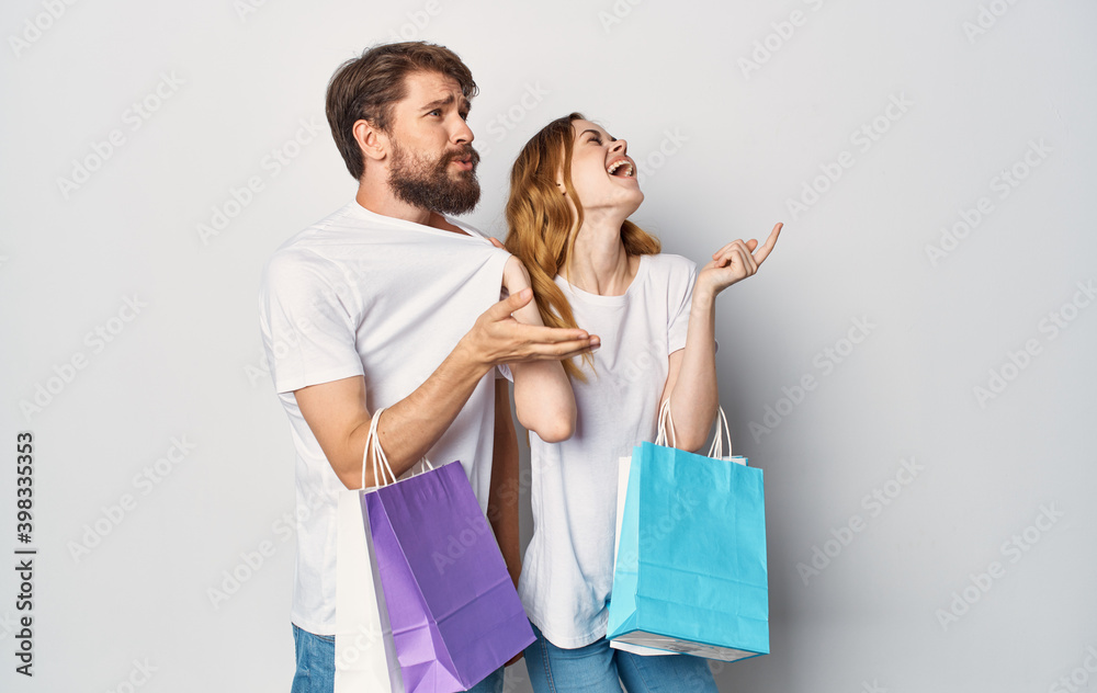 Cheerful young couple t-shirt jeans emotions joy shopping in the store Cheerful young couple t-shirt jeans emotions joy shopping in the store