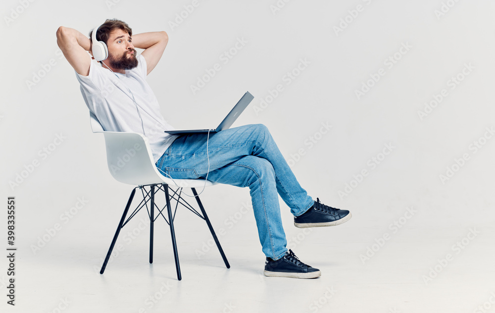 man in headphones in front of a laptop on a chair leisure lifestyle technology man in headphones in front of a laptop on a chair leisure lifestyle technology
