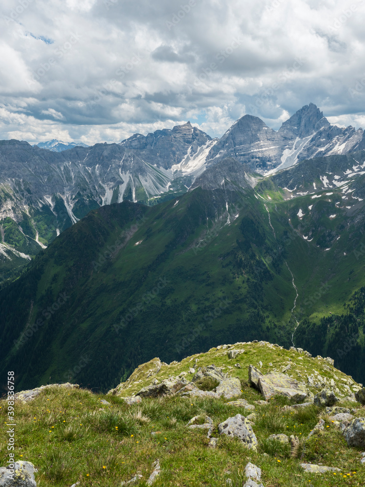 Naklejka premium view from Pramarnspitze saddle on Gschnitztal Valley and snow-capped moutain panorama at Stubai hiking trail, Stubai Hohenweg, Alpine landscape of Tyrol Alps, Austria. Summer blue sky, white clouds