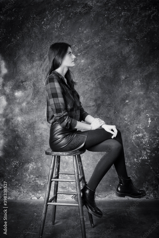 Studio portrait of young beautiful woman in a leather skirt Studio portrait of young beautiful woman in a leather skirt