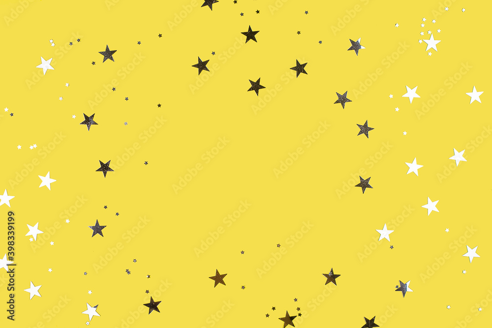 Obraz premium Gray silver stars on yellow background. Flat lay, top view. Colors of year. Copy space, frame