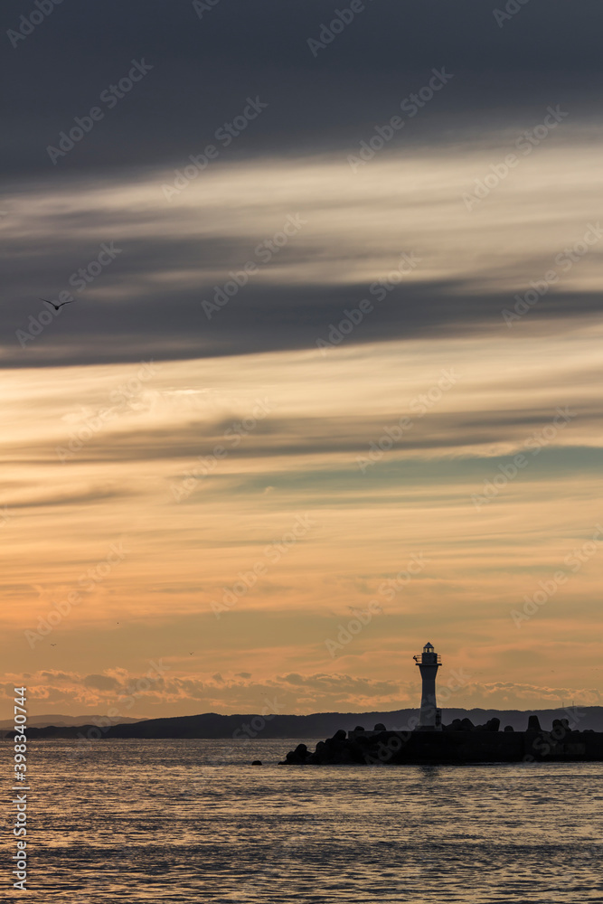 Kushiro Port Lighthouse where the silhouette is projected in the orange sky at sunset