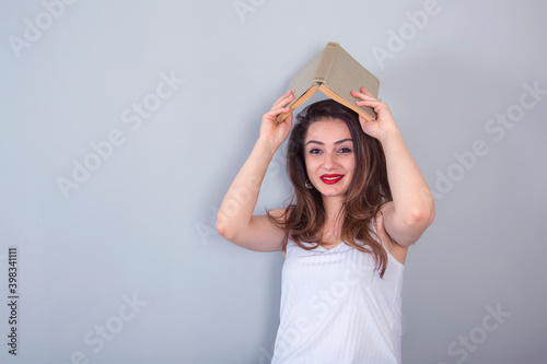 woman with book above head in studio