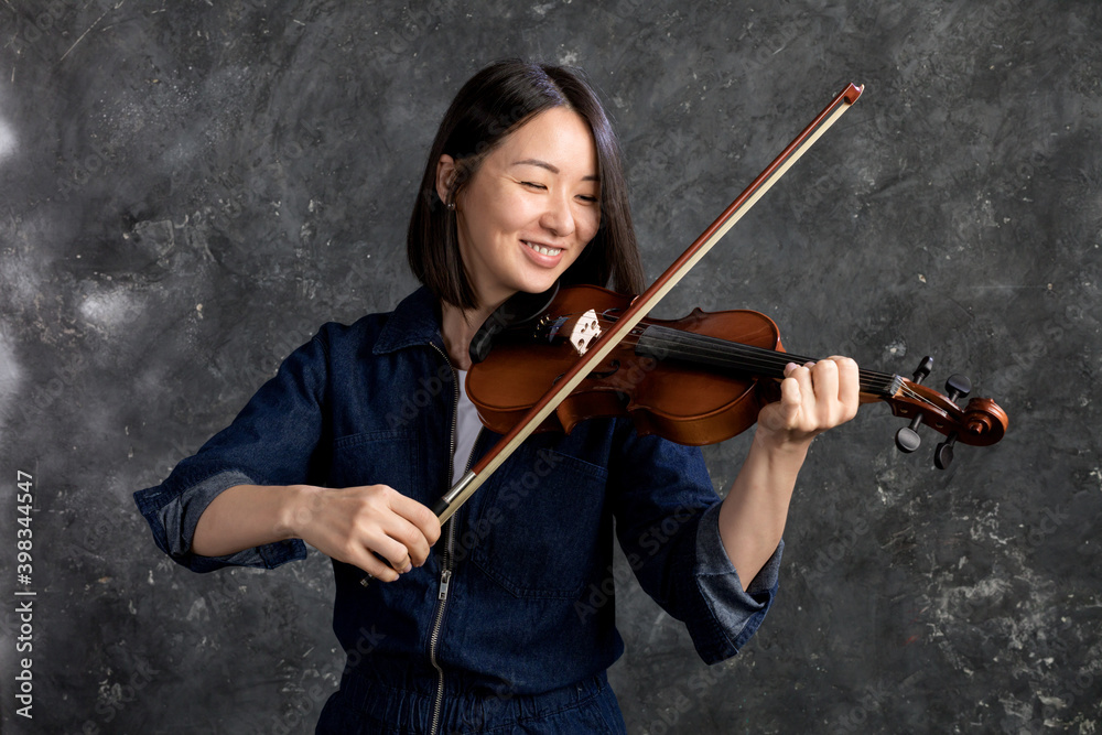 Beautiful korean woman plays violin studio emotional portrait.