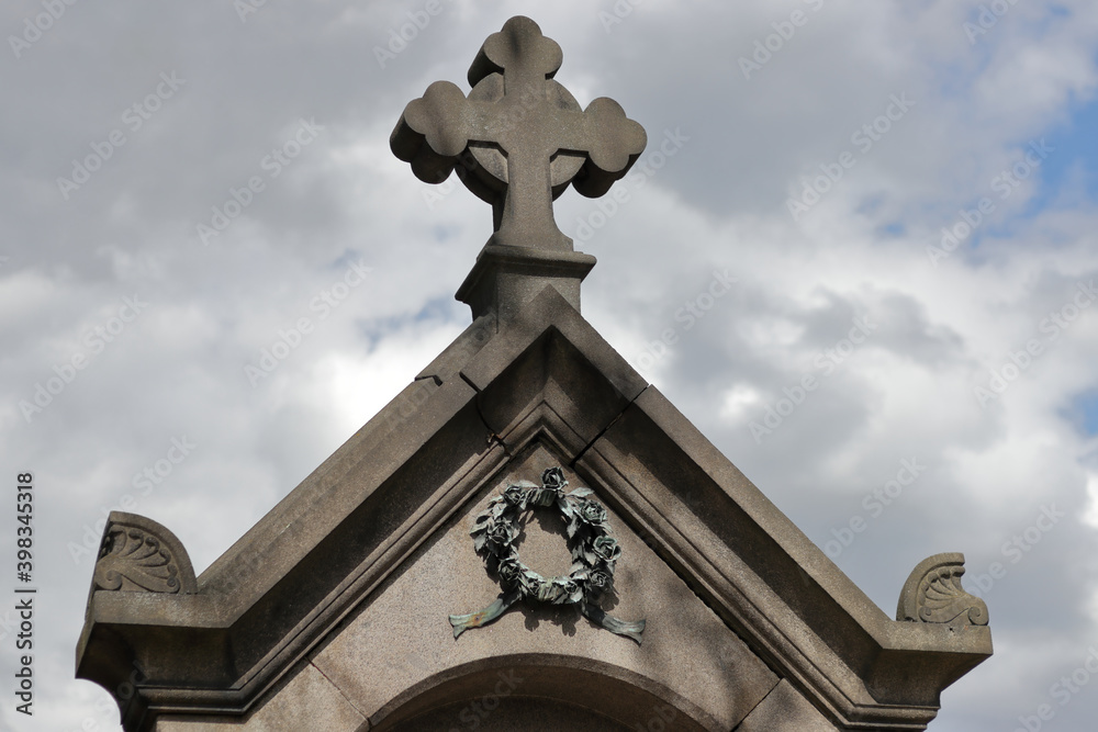 Cross on top of a tomb in a cemetery