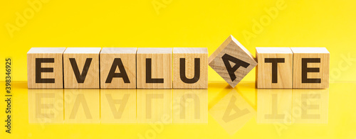 Photography evaluate word is made of wooden building blocks lying on the yellow table, conce