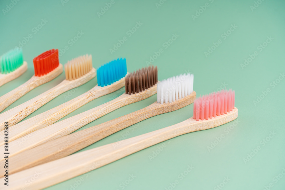 A set of Eco-friendly antibacterial toothbrushes made of bamboo wood on a light green background. Environmental care trends A set of Eco-friendly antibacterial toothbrushes made of bamboo wood on a light green background. Environmental care trends
