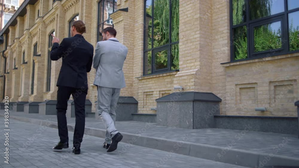 Back view business people talking on street. White collar men walking to work. Back view business people talking on street. White collar men walking to work.