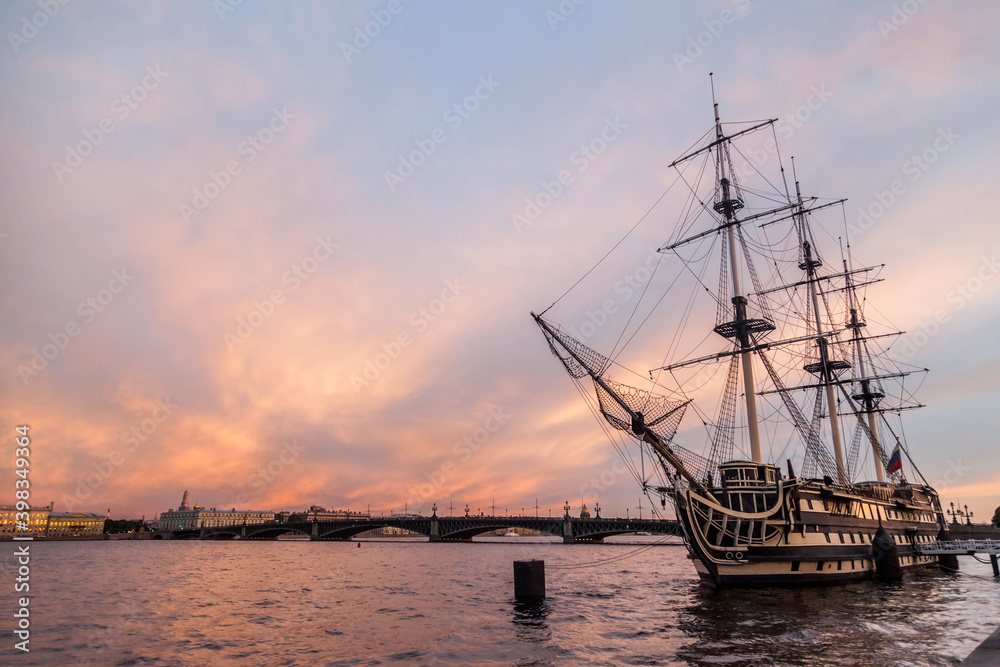 Old sailing frigate at the pier at sunset