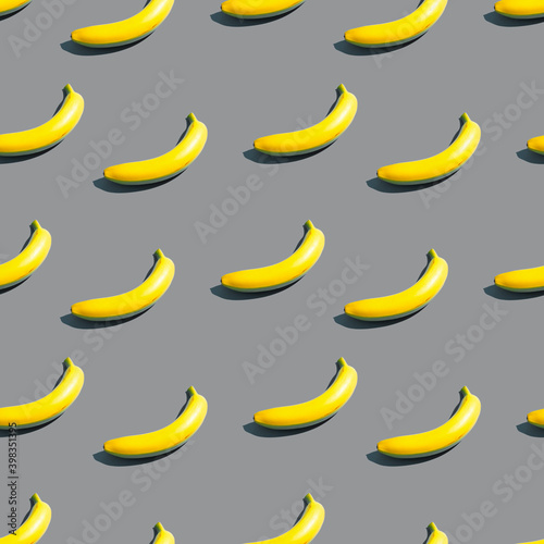 Pattern of bright yellow bananas on a blue background. Creative design background in color of the year