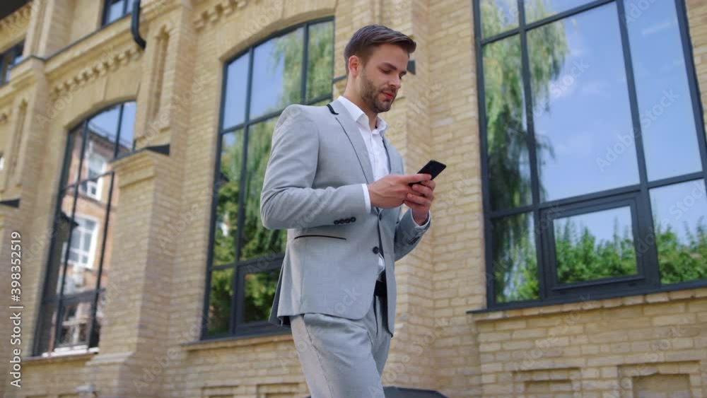 Businessman calling mobile phone on street. Suit man using cellphone outdoors.