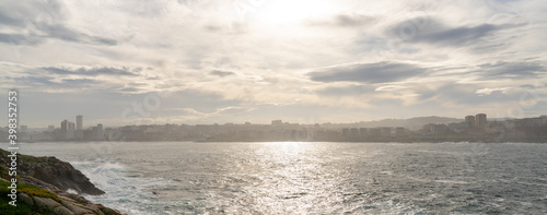 Fotografie skyline and bay of La Coruna with mist and fog lifting up in the golden morning