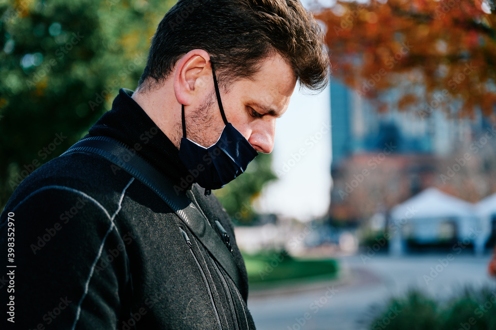 Baltimore during Covid-19 as seen in November 2020. A man wearing a mask is checking his phone. Baltimore during Covid-19 as seen in November 2020. A man wearing a mask is checking his phone.