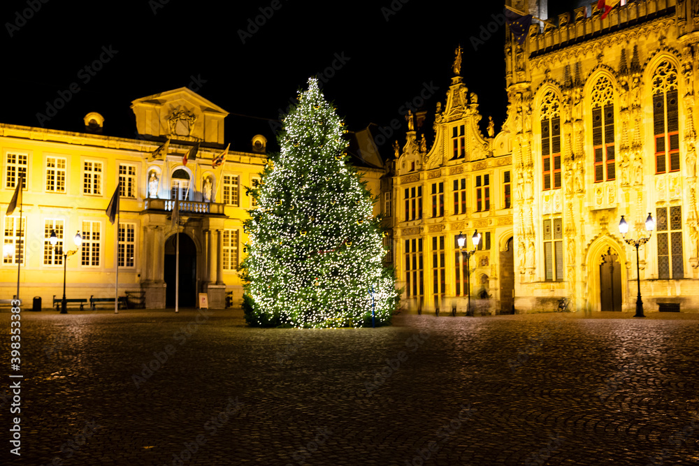 Christmas tree on Burg square and City Hall in Bruges, Belgium. Festive lights and decorations.