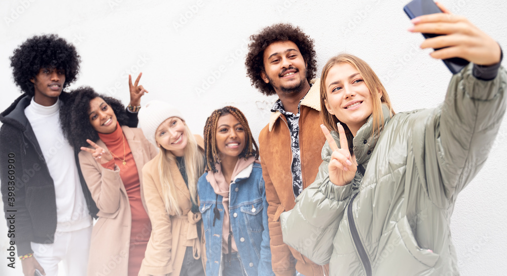 Happy multiracial friends taking selfie with mobile phone, smiling. Happy multiracial friends taking selfie with mobile phone, smiling.