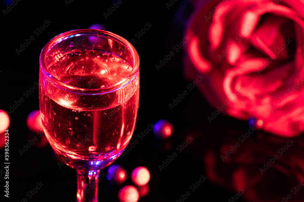 Beautiful Crystal Wine Glass Goblet Of Red Color Alcohol Shot For Late Night Happy New Year Party Theme With Reflection Of Colorful Rose Decoration In Blur And Vibrant Light On Dark Black Background Beautiful Crystal Wine Glass Goblet Of Red Color Alcohol Shot For Late Night Happy New Year Party Theme With Reflection Of Colorful Rose Decoration In Blur And Vibrant Light On Dark Black Background