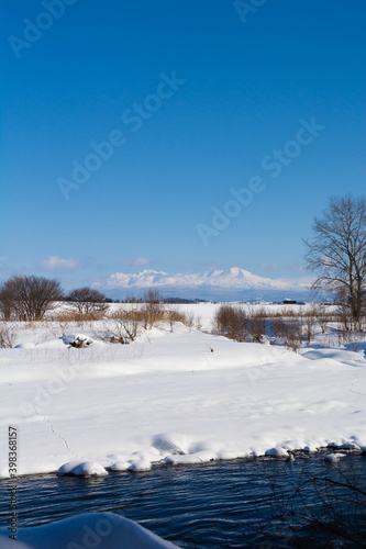 冬の河原と雪山と青空 大雪山 