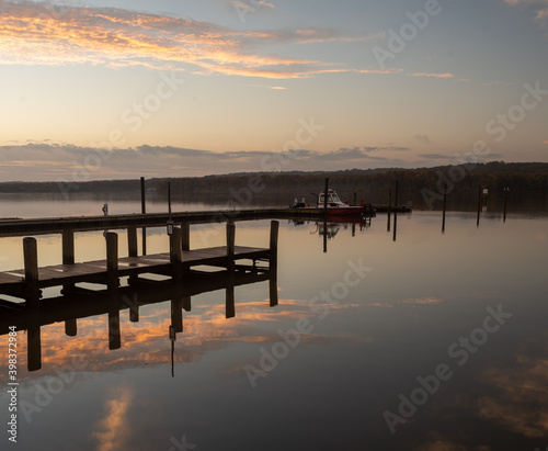 Sunrise at the River with Rescue Boat at the Pier with Reflections in the Still and Calm Water
