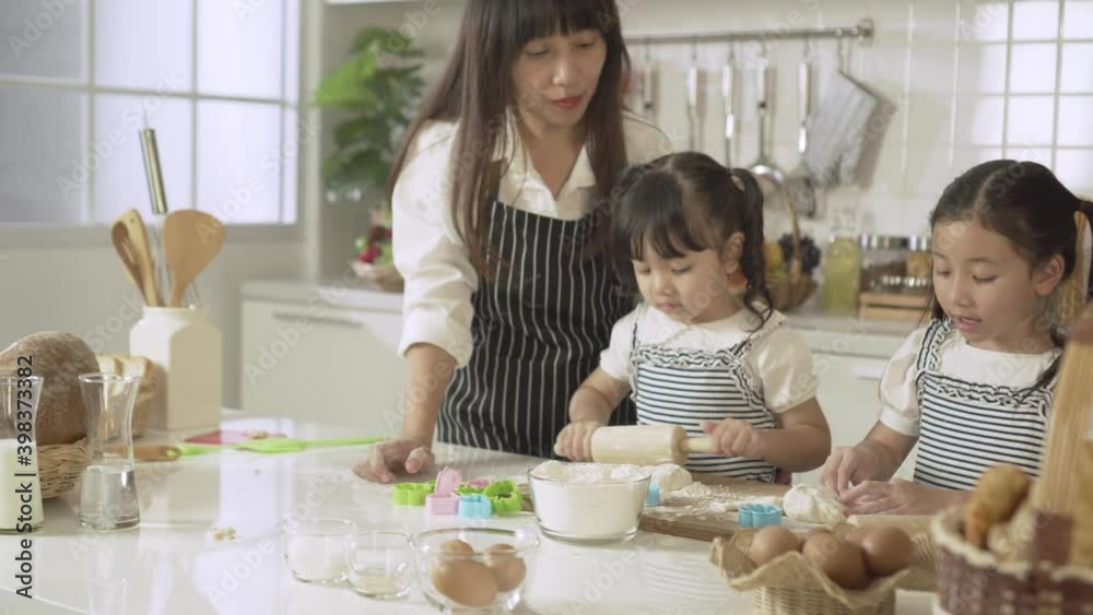 Mother and daughter knead dough, bake and play together in kitchen. Mother and daughter knead dough, bake and play together in kitchen.