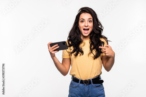 Young woman playing games in her phone isolated over a white background