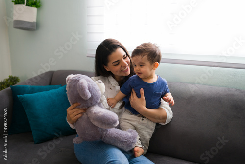 Woman with baby playing teddy bear