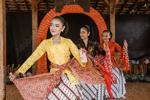 portrait of three young women presenting traditional Javanese dance movements photo