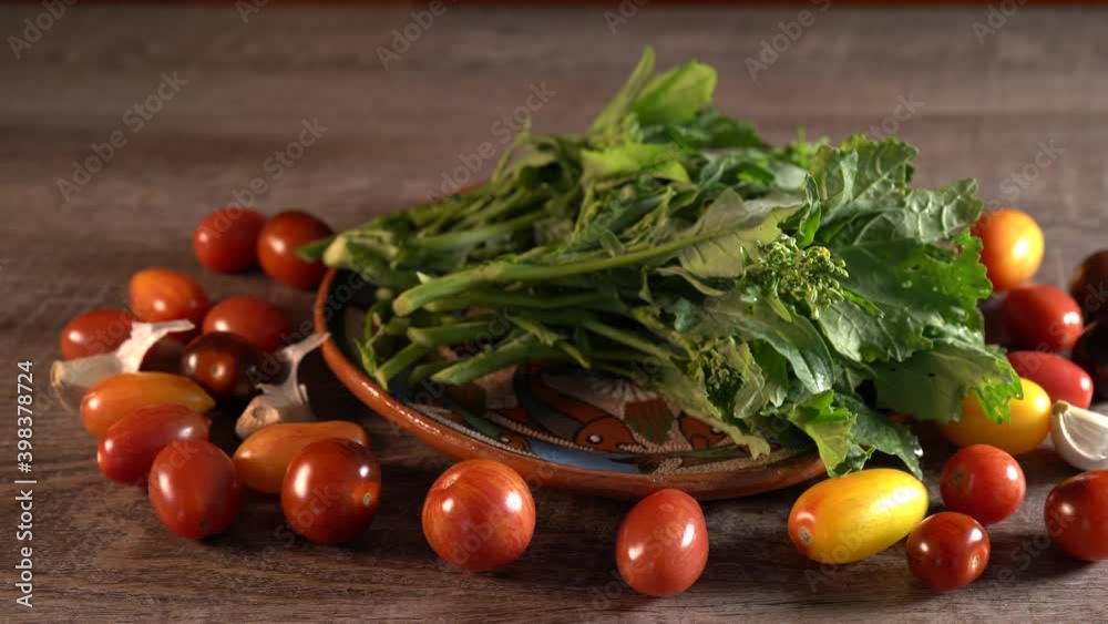 Dolly to the left of beautifully lit cherry tomatoes and broccoli rabe. Dolly to the left of beautifully lit cherry tomatoes and broccoli rabe.