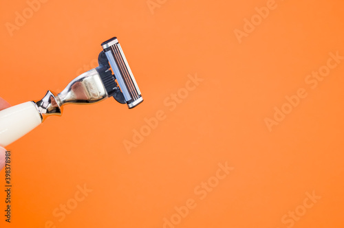 Closeup shot of a man's razor on orange background