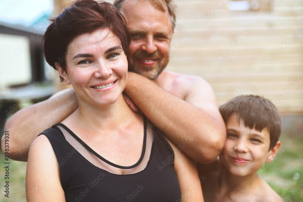 A happy village family looks at the camera and smiles. Natural emotions. Friendly parents and their son A happy village family looks at the camera and smiles. Natural emotions. Friendly parents and their son