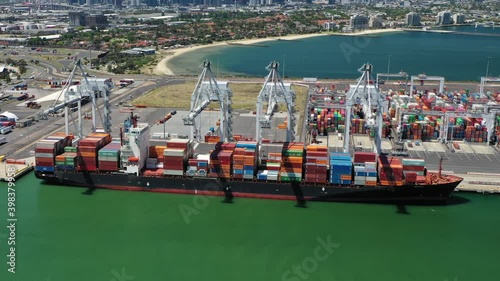 Aerial hyperlapse of cargo ship loading containers at the port