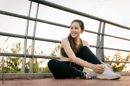 Beautiful asian women in sportswear exercising outdoors in the park during sunset. Healthy women concept.