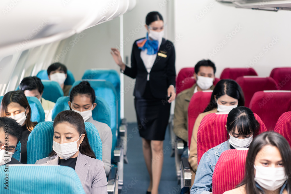Beautiful Asian flight attendant wearing face mask, providing services Beautiful Asian flight attendant wearing face mask, providing services
