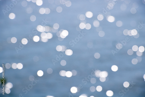 Bokeh from sunlight reflected on the water surface texture background, Represents travel in the warm sunny summer Reflected on the water surface giving a feeling of relaxation.
