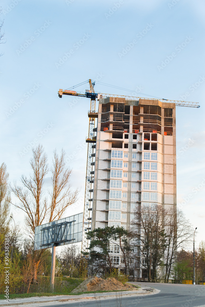 Construction of new house or building. General view. Unfinished cement building in the summer. The introduction of urbanization into nature. Capital construction in Ukraine. Tower crane