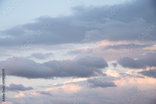 Beautiful sky background. Light blue sky with soft pink, orange, and gray clouds. Perfect for sky replacement. High quality photo © Avi