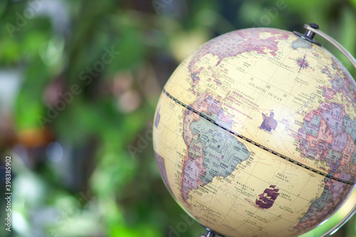 A globe in front of a blurred green plant background